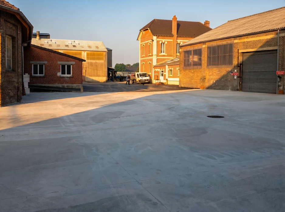Cour industrielle extérieure au coucher du soleil, entre bâtiments en briques rouges