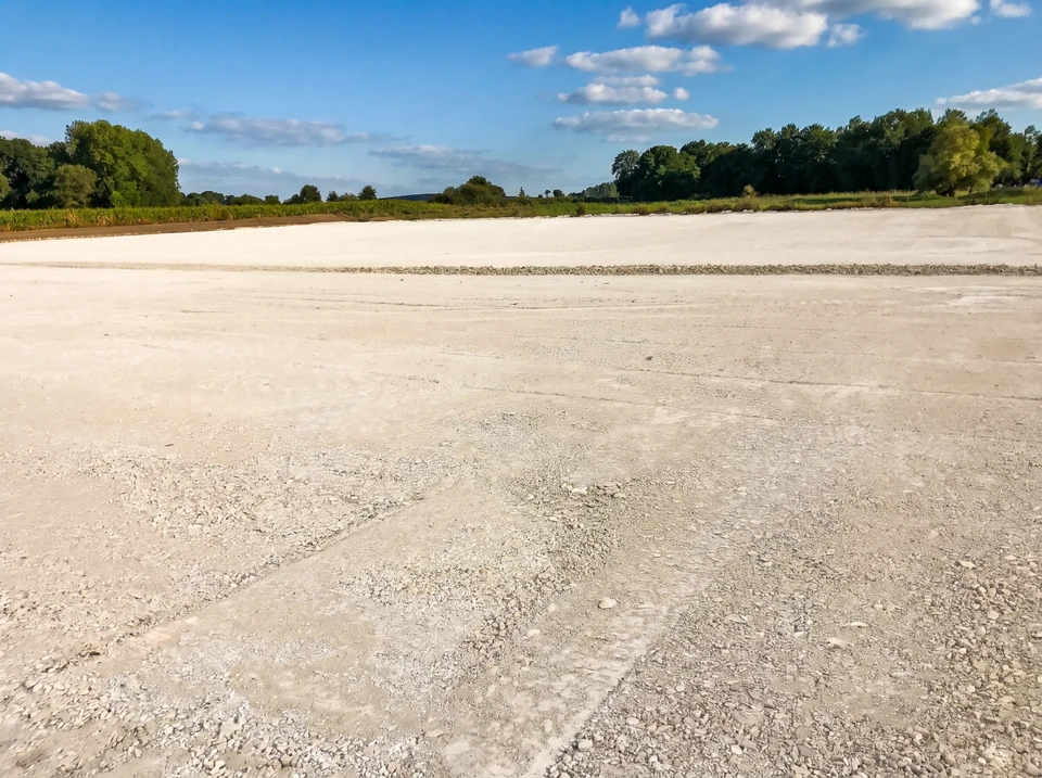 Chantier de terrassement en extérieur avec pelleteuse compacte à chenilles caoutchouc effectuant des travaux d'excavation
