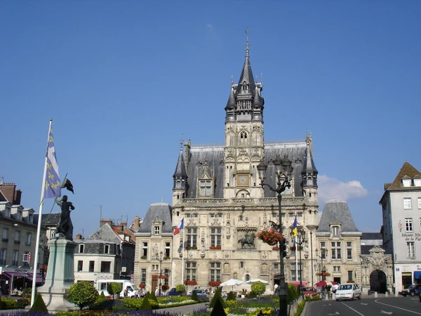 Vue a&eacute;rienne ou paysage urbain-rural de Compi&egrave;gne montrant le tissu urbain avec immeubles, routes et infrastructures, compl&eacute;t&eacute; par des zones agricoles et industrielles environnantes. L'image doit transmettre l'environnement r&eacute;gional professionnel o&ugrave; intervient l'entreprise de g&eacute;nie civil, illustrant clairement Compi&egrave;gne comme zone d'intervention, sans personnages ni &eacute;l&eacute;ments distrayants.