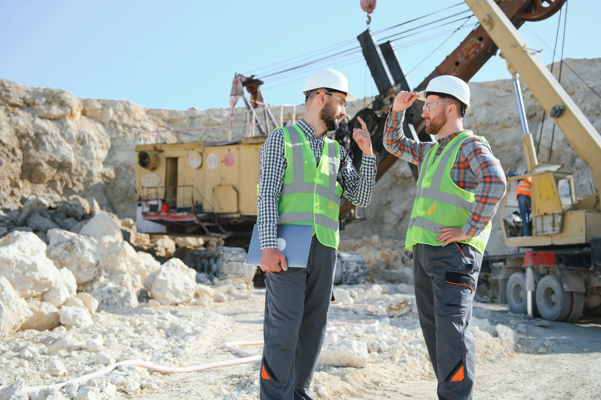 Chantier de terrassement en extérieur avec pelleteuse hydraulique jaune sur chenilles opérant au milieu de monticules de terre excavée et de gravats