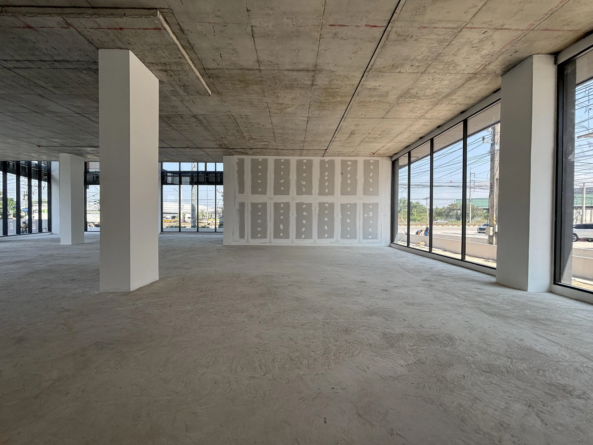 Chantier de construction urbain en extérieur avec ouvriers équipés de casques de sécurité travaillant sur une structure en béton armé