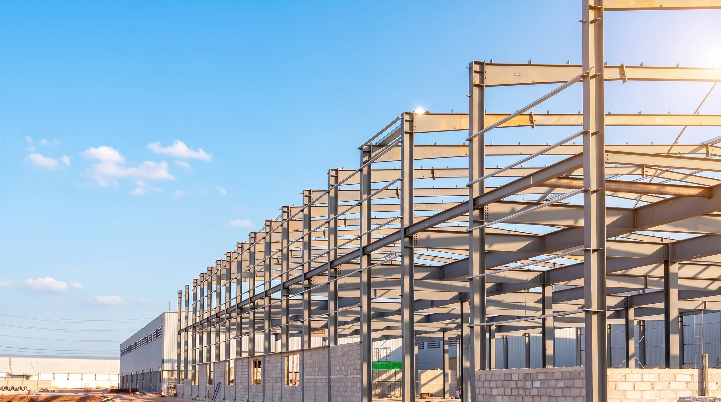 Chantier de construction extérieur avec éléments préfabriqués en béton armé disposés sur site
