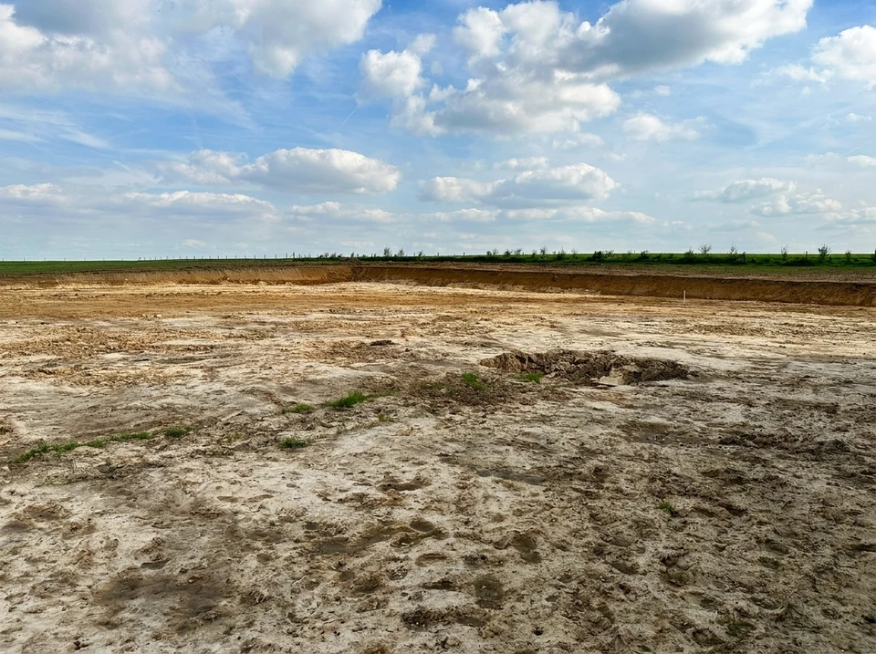 Chantier de terrassement en extérieur avec pelleteuse compacte à chenilles caoutchouc effectuant des travaux d'excavation