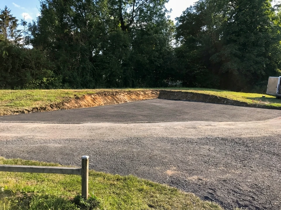 Chantier de terrassement en extérieur avec pelleteuse hydraulique jaune sur chenilles opérant au milieu de monticules de terre excavée et de gravats